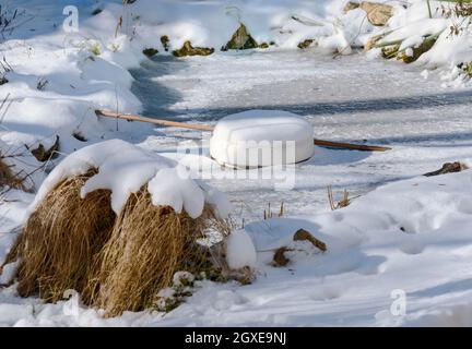 Médicament de glace flottante faite de styrofoam dans un étang gelé Banque D'Images