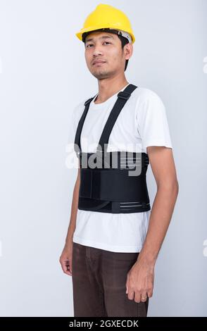 Travailleur Homme debout porter dos ceinture de soutien corps protéger la posture Banque D'Images