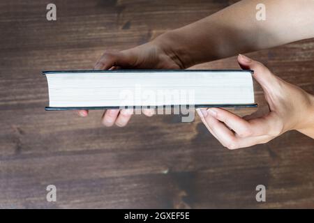 un livre fermé dans les mains d'une femme Banque D'Images