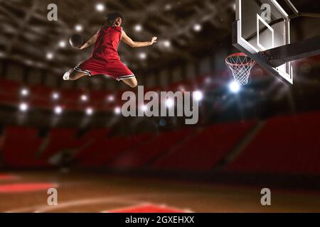 Un joueur de basket-ball claque le ballon dans le panier Banque D'Images