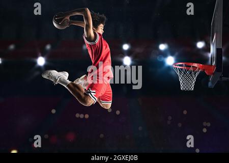 Un joueur de basket-ball claque le ballon dans le panier Banque D'Images