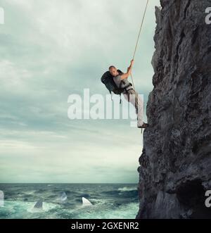 Explorer grimpe une montagne avec le risque de tomber sur la mer profonde avec les requins Banque D'Images