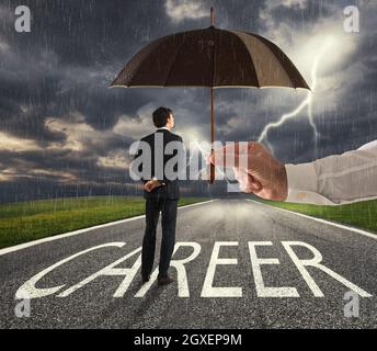 Homme d'affaires prêt à commencer une longue carrière difficile avec une grande aide d'un parapluie. Concept de soutien et d'assistance Banque D'Images