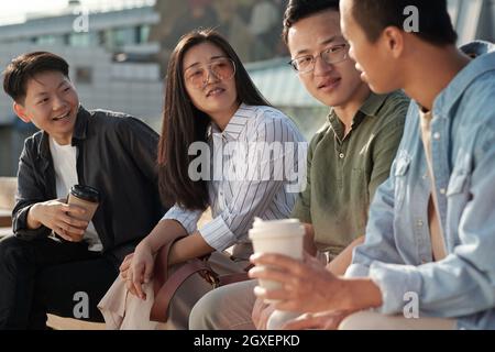 Groupe de collègues discutant des points de travail lors d'une réunion en plein air Banque D'Images