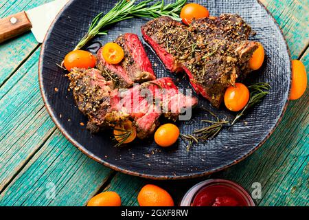 Steak de bœuf fraîchement coupé en tranches rôti au kumquat, au romarin et aux épices. Entrecote de veau sur une plaque Banque D'Images