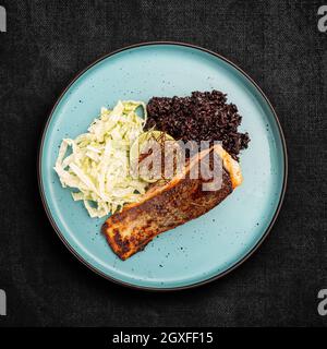 Saumon grillé avec riz noir et laitue iceberg, vue de dessus, plat Banque D'Images