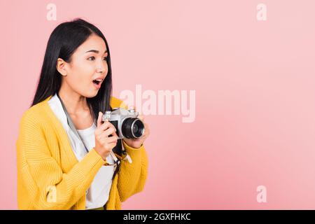 Attrayant heureux portrait asiatique style de vie belle jeune femme excitée sourire photographe tenant un appareil photo rétro vintage prêt à filmer isolat Banque D'Images