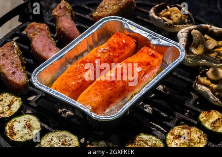 viande de veau, saumon et courgettes sur le grill du jardin au charbon de bois Banque D'Images