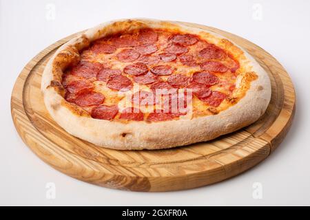 Vue de dessus de pizza chaude sur un stand en bois. Pizza au pepperoni. Base de tomate, deux types de fromage et beaucoup de salami. Banque D'Images