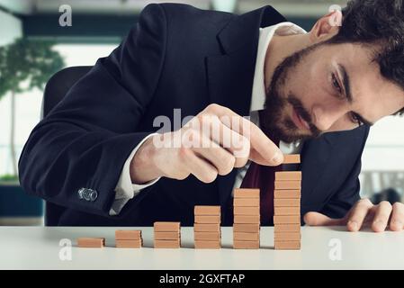 Homme d'affaires construit un escalier avec de petites briques Banque D'Images