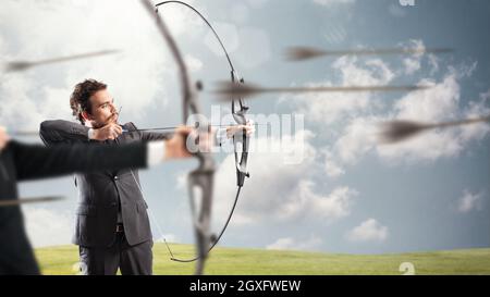 Les hommes d'affaires en concurrence avec l'arc et les flèches pour atteindre et atteindre de nouvelles cibles Banque D'Images