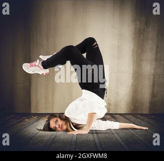 Danseuse agile dans une posture de breakdance Banque D'Images