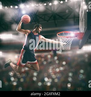 Un joueur de basket-ball claque le ballon dans le panier Banque D'Images