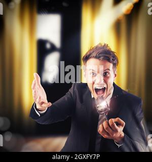 Homme hurlant au microphone sur le théâtre Banque D'Images