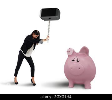 Une femme casse avec un marteau une pigegibank Banque D'Images