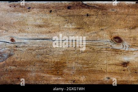 Un panneau en bois rustique horizontal de bois vieilli. Le bois est abîmé, fortement texturé et coloré jaune, or et marron. Banque D'Images