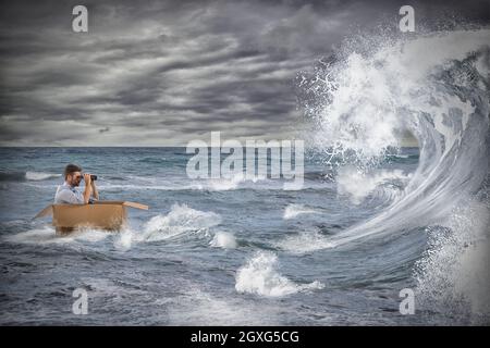 Homme d'affaires dans un carton voiles dans une tempête en mer. Gérer la crise comme un concept de mer orageux Banque D'Images