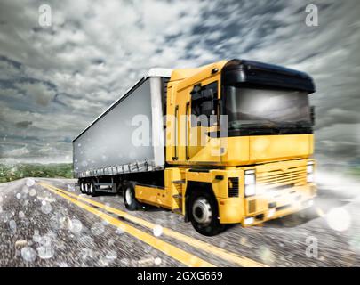 Camion de transport avec feux sur route sous la pluie Banque D'Images