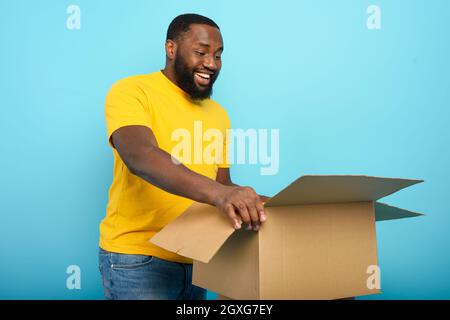 Happy man reçoit un paquet de commande en ligne. Happy expression. Banque D'Images