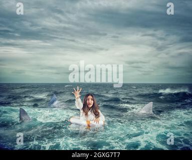 Une femme d'affaires dans l'océan avec une ceinture de sauvetage entourée de requins demande de l'aide Banque D'Images