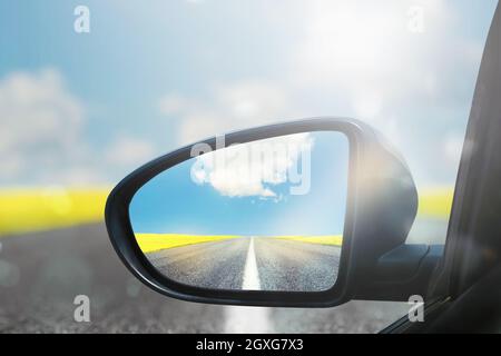 Miroir d'aile d'une voiture avec le chemin de beau panorama réfléchi Banque D'Images