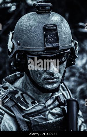 Grimy sale et fatigué visage de l'armée américaine Ranger, jeune garçon portant des lunettes et casque de combat. Gros plan Banque D'Images