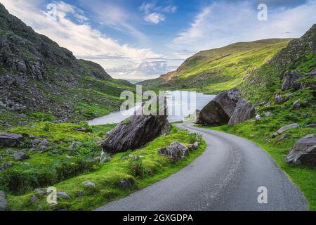 Route sinueuse entre deux moitiés de roche ou de bloc à Gap of Dunloe, Black Valley, montagnes MacGillycuddys Reeks, Ring of Kerry, Irlande Banque D'Images