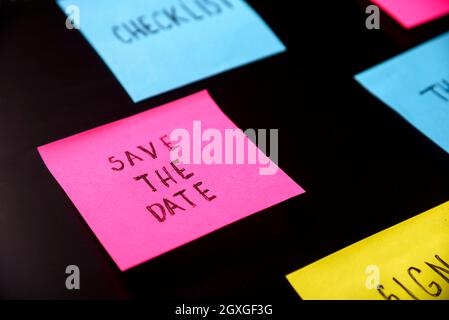 Notes adhésives colorées sur le tableau noir. Conservez la date inscrite sur l'étiquette à l'ananas. N'oubliez pas d'enregistrer le concept d'entreprise de date. Banque D'Images