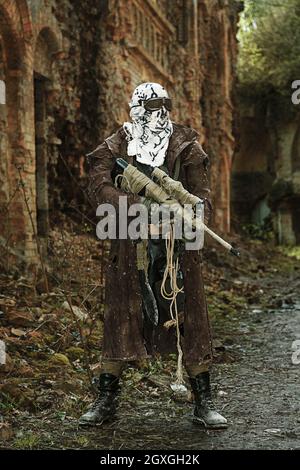 Post-apocalypse nucléaire. Seul survivant en lambeaux et masque à gaz sur les ruines de la ville détruite Banque D'Images