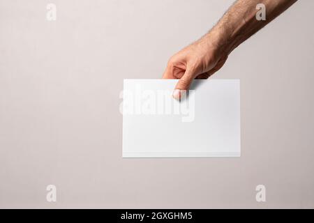 Main mâle tenant un catalogue fermé avec couverture vierge, modèle de série maquette prêt pour votre conception, chemin de sélection de couverture inclus. Banque D'Images