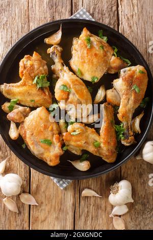 Poulet à l'ail espagnol Pollo Al Ajillo gros plan sur une assiette sur la table. Vue verticale du dessus Banque D'Images