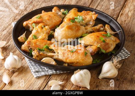 Poulet à l'ail Pollo al Adillo plat de tapas espagnol traditionnel en gros plan sur une assiette sur la table. Horizontale Banque D'Images