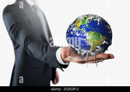 Un homme d’affaires qui tient la terre qui fond . arrête le réchauffement climatique Banque D'Images