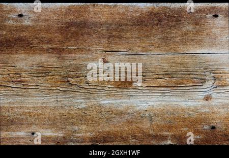 Un panneau en bois rustique horizontal de bois vieilli. Le bois est abîmé, fortement texturé et coloré jaune, or et marron. Banque D'Images