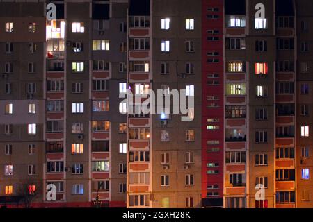 Fenêtres éclairées dans un bâtiment nocturne en hauteur. Fenêtres éclairées dans un bloc de méplats opposés. Fenêtres éclairées sur le gratte-ciel la nuit. Maison moderne Banque D'Images