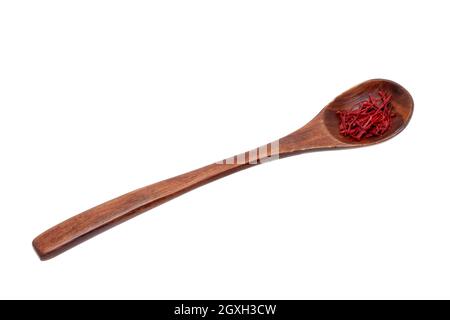 Fond de safran. Gros plan de fils d'épices ou de torons safran rouges dans une cuillère en bois rustique isolée sur un fond blanc. Masque.Macro. Banque D'Images