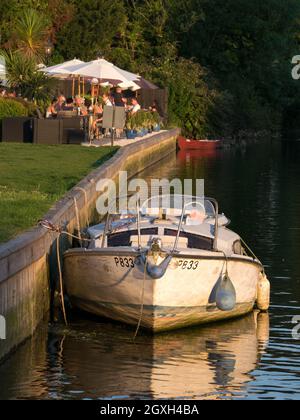 Bateau amarré à côté de l'attrayant Riverside Pub Garden sur les Norfolk Broads, Thorpe St Andrew, Norwich, Norfolk, Angleterre, ROYAUME-UNI, Banque D'Images