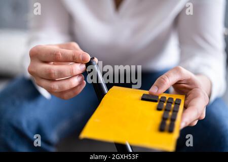 Coller le tampon de feutre sur le pied de chaise pour une surface en bois Sécurité Banque D'Images