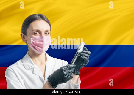 La jeune fille prépare la vaccination contre le fond du drapeau de la Colombie. Concept de vaccination Colombie. Banque D'Images