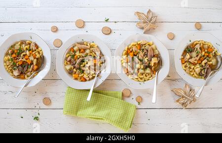 Table avec soupe de poulet sur fond de bois blanc. Pose à plat Banque D'Images