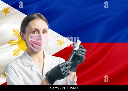 La jeune fille prépare la vaccination contre le fond du drapeau des Philippines. Concept de vaccination Philippines. Banque D'Images
