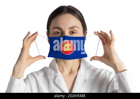 Respirateur avec drapeau de l'Association des nations de l'Asie du Sud-est le docteur met sur le masque médical isolé sur fond blanc. Banque D'Images