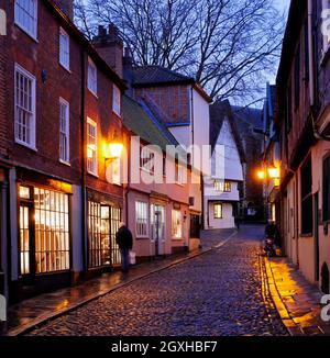 La colline historique pavée d'Elm à Nightfall avec ses lanternes dorées et ses fenêtres illuminées, Norwich, Norfolk, Angleterre, Royaume-Uni Banque D'Images