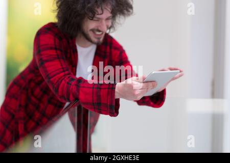 Jeune travailleur indépendant en peignoir travailler à domicile à l'aide de tablet computer Banque D'Images