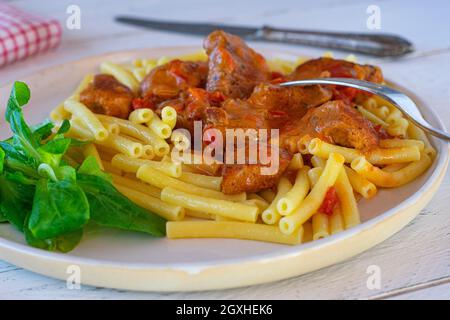 Goulash de dinde paprika crémeux avec macaroni servi sur une assiette sur une table de cuisine Banque D'Images