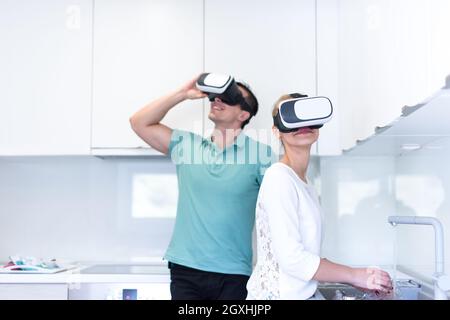 Happy young couple acquérir de l'expérience à l'aide de casque VR-verres de la réalité virtuelle à la maison Banque D'Images
