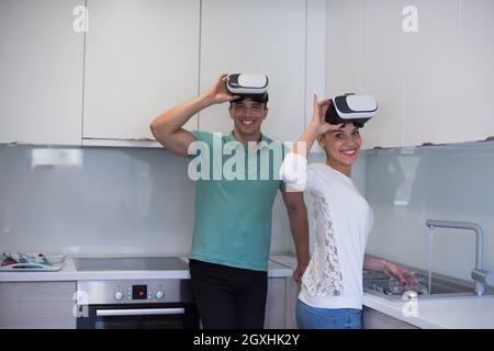Happy young couple acquérir de l'expérience à l'aide de casque VR-verres de la réalité virtuelle à la maison Banque D'Images