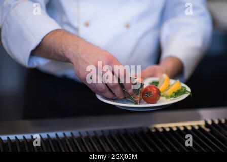 Master chef mains cuisine Poisson saumon grillé avec des pommes de terre sur une cuisine de restaurant Banque D'Images