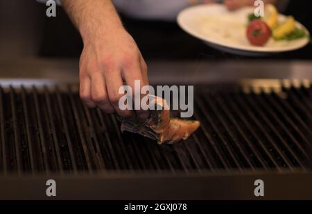 Master chef mains cuisine Poisson saumon grillé avec des pommes de terre sur une cuisine de restaurant Banque D'Images