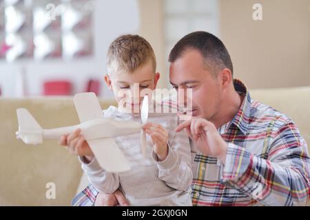 Le père et le fils de l'assemblage à jouet avion accueil moderne salle de séjour piscine Banque D'Images